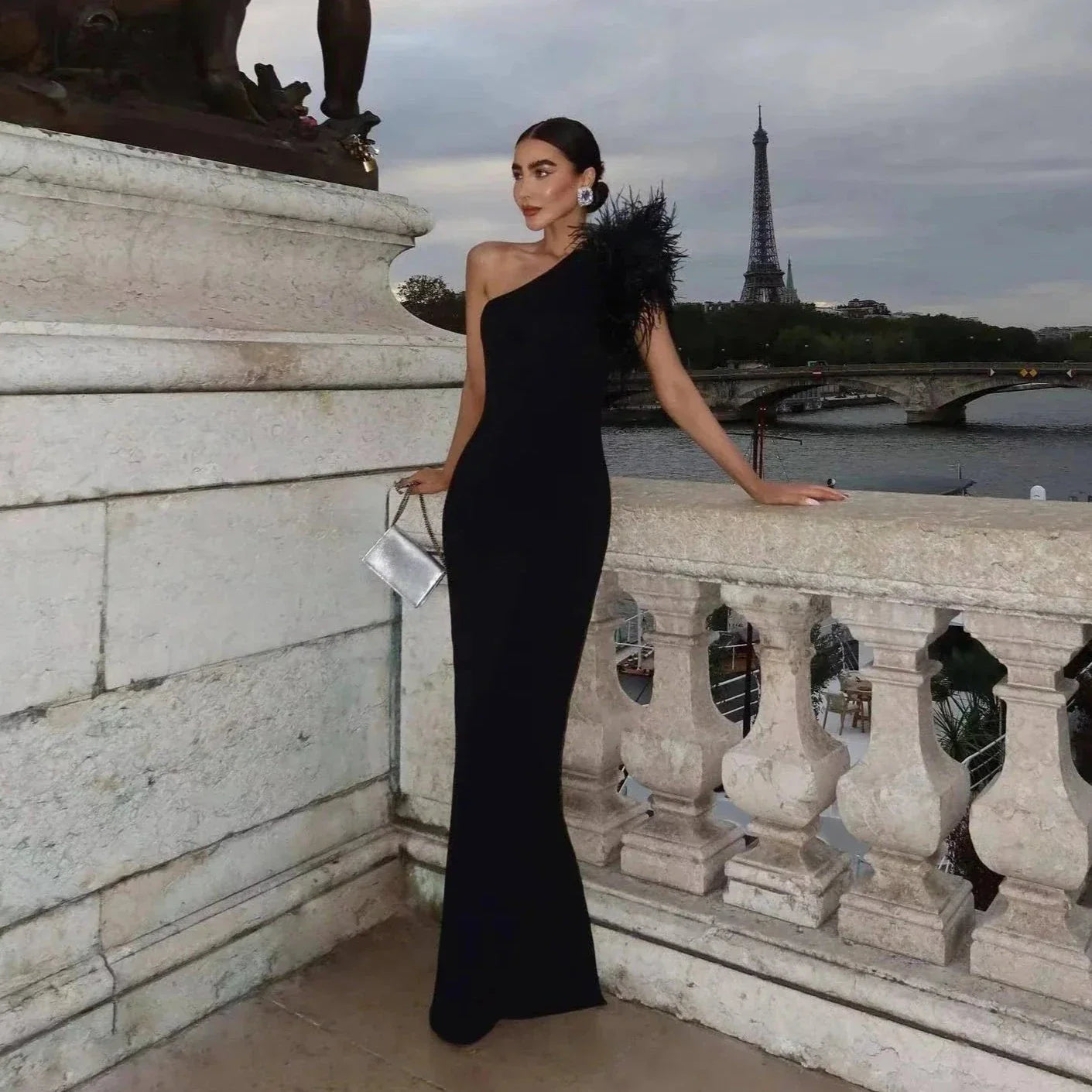 Vestido largo elegante con un solo hombro y plumas, delicado en la oscuridad