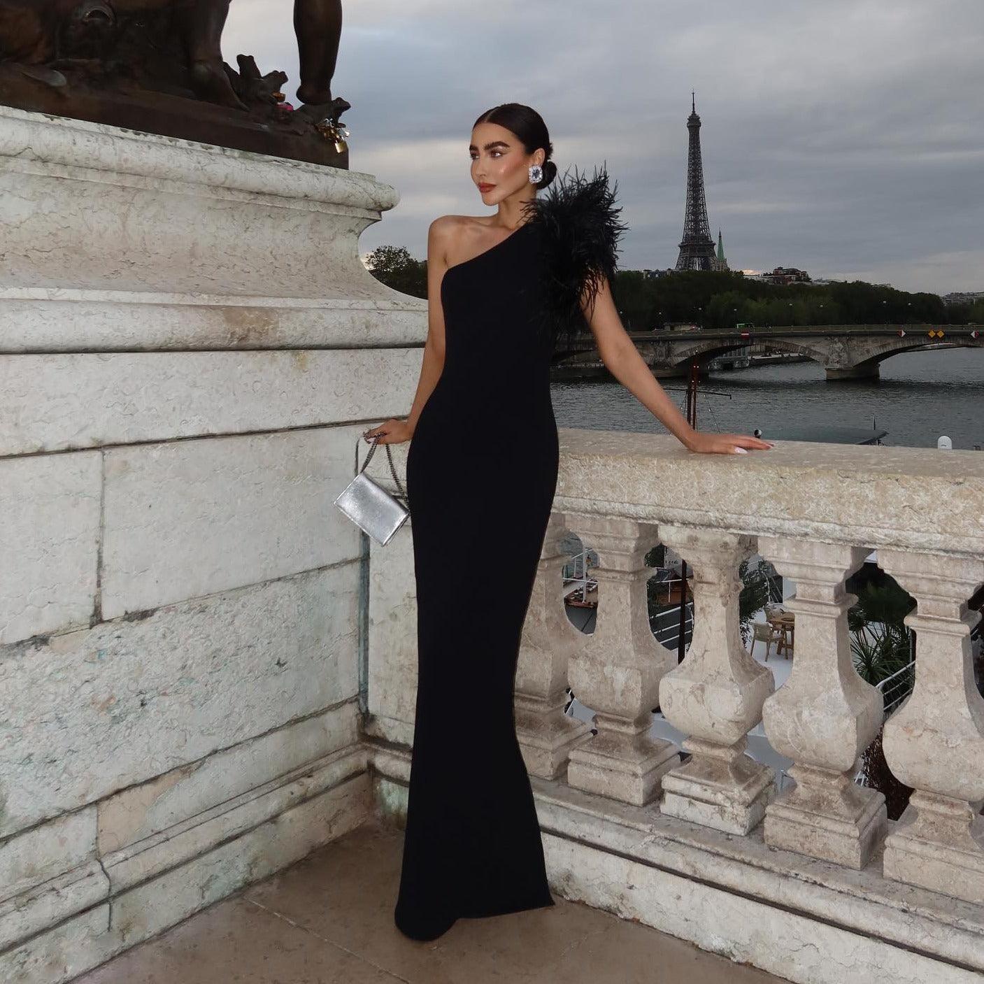 Vestido largo elegante con un solo hombro y plumas, delicado en la oscuridad