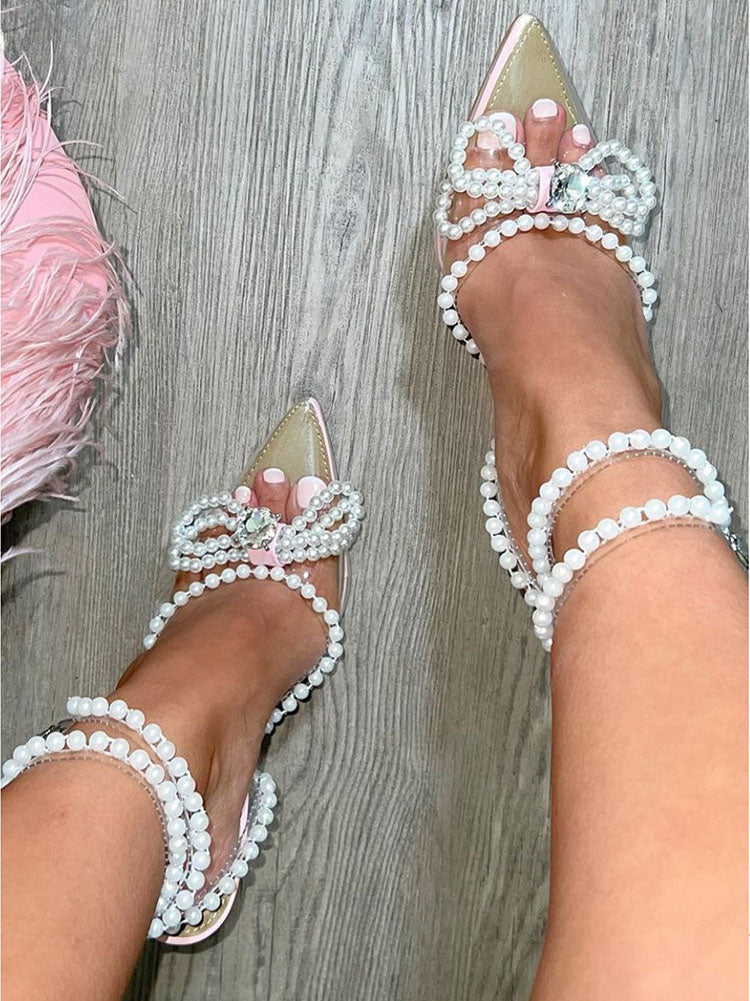 Tacones transparentes con punta puntiaguda y lazo de perla