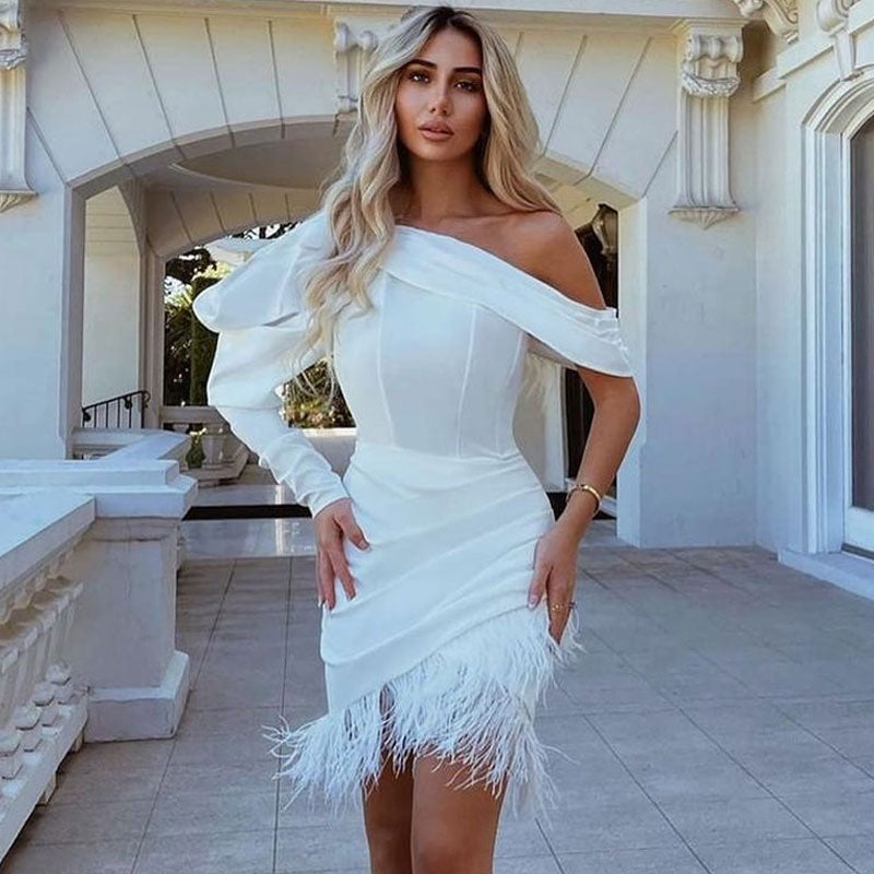 Minivestido blanco con corsé de plumas y un hombro con mangas abullonadas